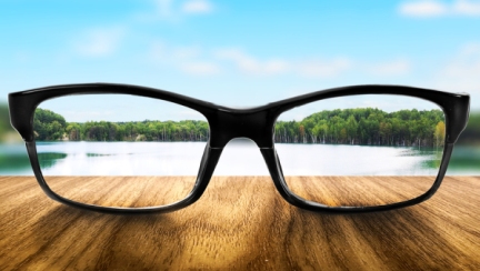 Clear lake in glasses on the background of blurred nature